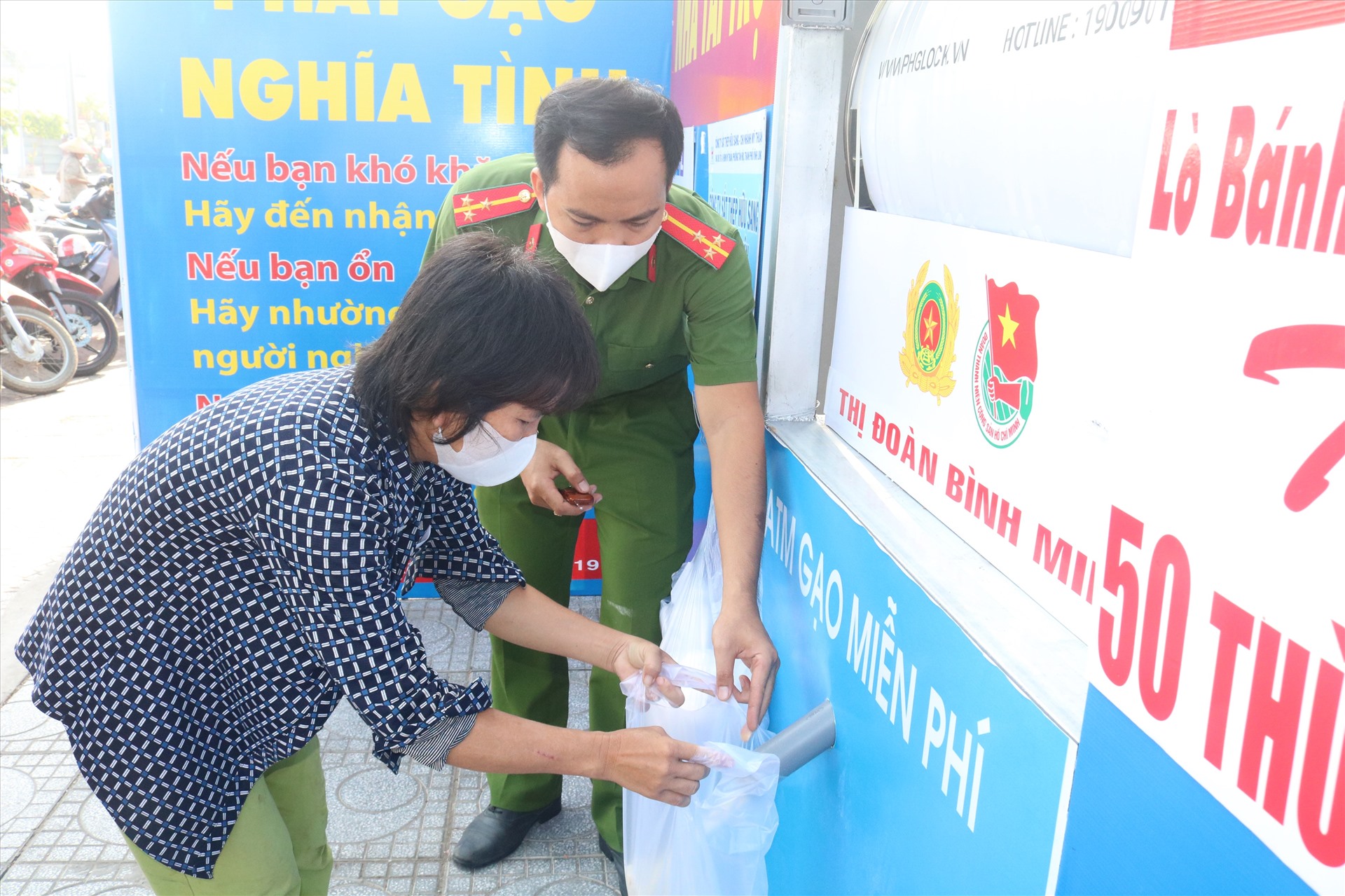 Người dân đến nhận gạo được sự hỗ trợ của các chiến sĩ Công an. Ảnh: T.L