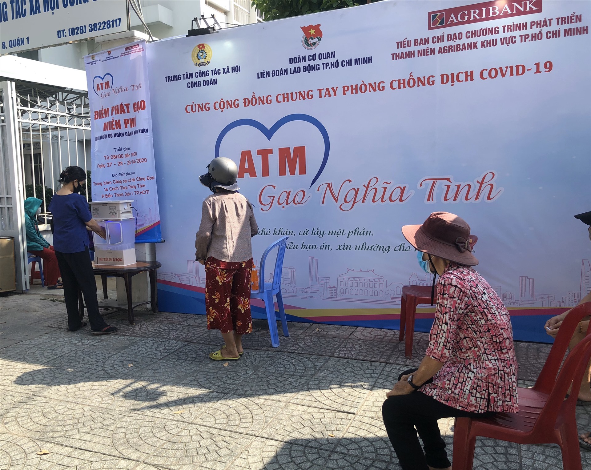 NLĐ được phát phiếu nhận quà phải đảm bảo đeo khẩu trang, giữ khoảng cách an toàn và thực hiện rửa tay trước khi vào khu vực nhận gạo. Ảnh: Thu Hà.