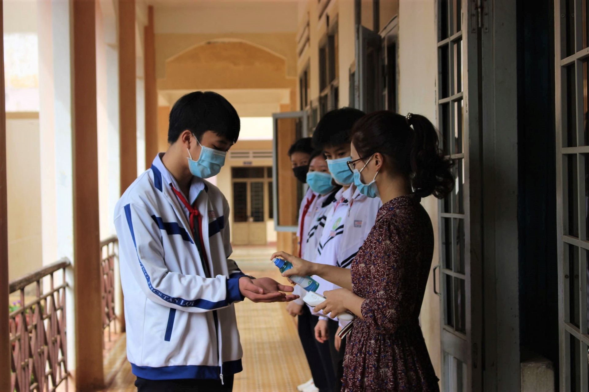 Nhà trường tiến hành đo thân nhiệt, rửa tay sát khuẩn cho các em học sinh trước khi vào lớp. Ảnh: Huỳnh Thủy