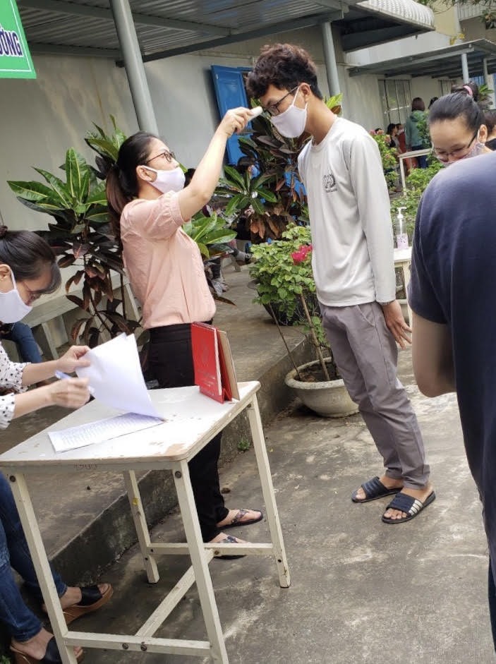 Người lao động ở Cty Vinakad vẫn phải khai báo ý tế, đo thân nhiệt... Ảnh: Hồ Sỹ Tân