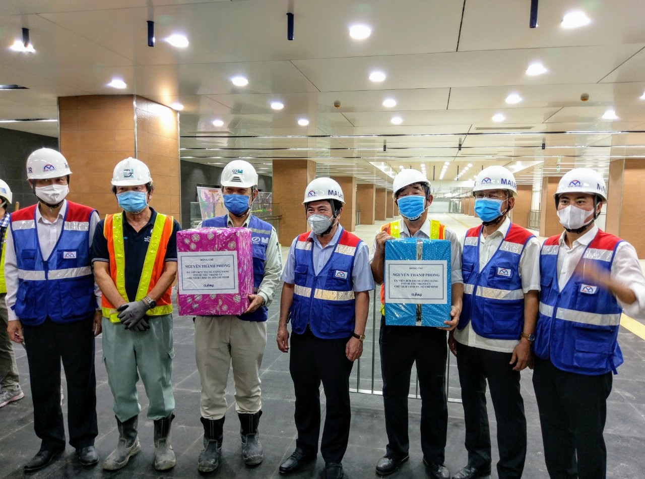 Chủ tịch UBND TPHCM Nguyễn Thành Phong (giữa) tặng quà cho đội ngũ kỹ sư, công nhân thi công ga Nhà hát Thành phố. Ảnh: Minh Quân