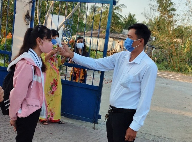 Kiểm tra thân nhiệt cho học sinh trước khi vào khuôn viên trường học (ảnh Nhật Hồ)