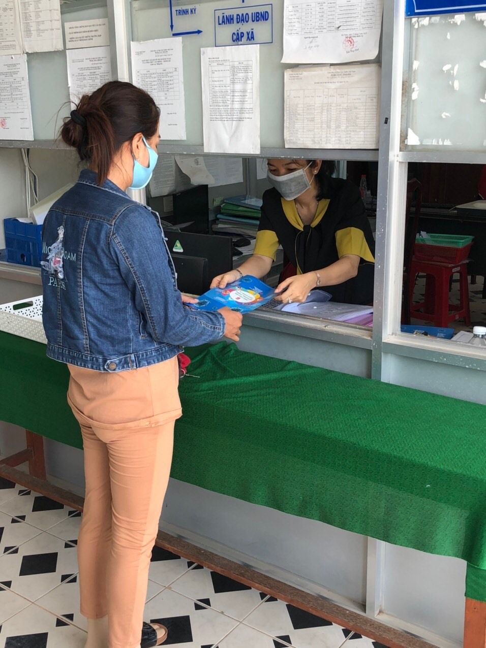 Công chức xã tuyên truyền về dịch bệnh khi người dân đến làm giấy tờ. Ảnh: K.Q