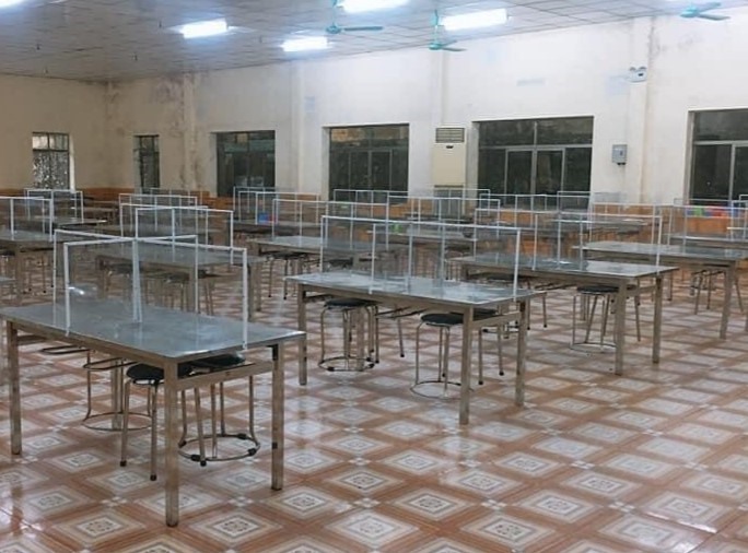 Tại Công ty than Uông Bí, mỗi bàn ăn được lắp thêm các tấm kính để ngăn cách giữa các công nhân ngồi ăn. Ảnh: CTV
