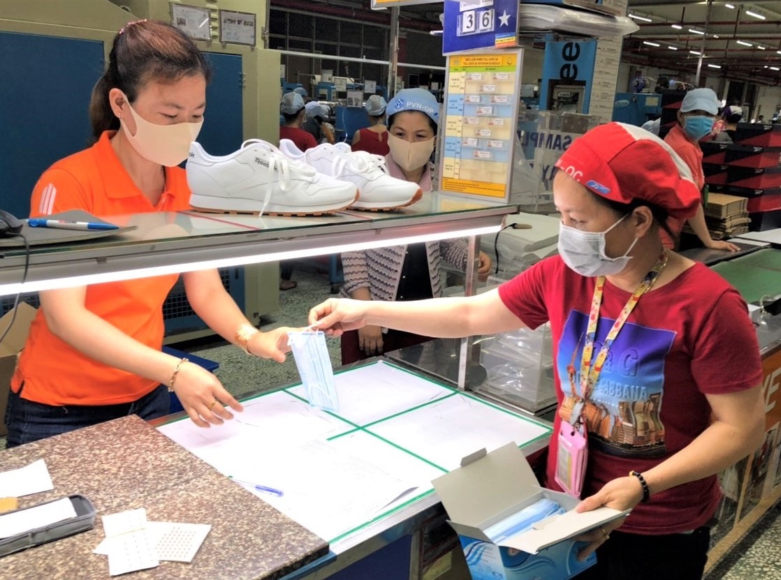 Mỗi công nhân Công ty PouYuen được phát một khẩu trang y tế trong sáng 9.4 để phòng chống lây nhiễm dịch COVID-19. Ảnh C.P.N