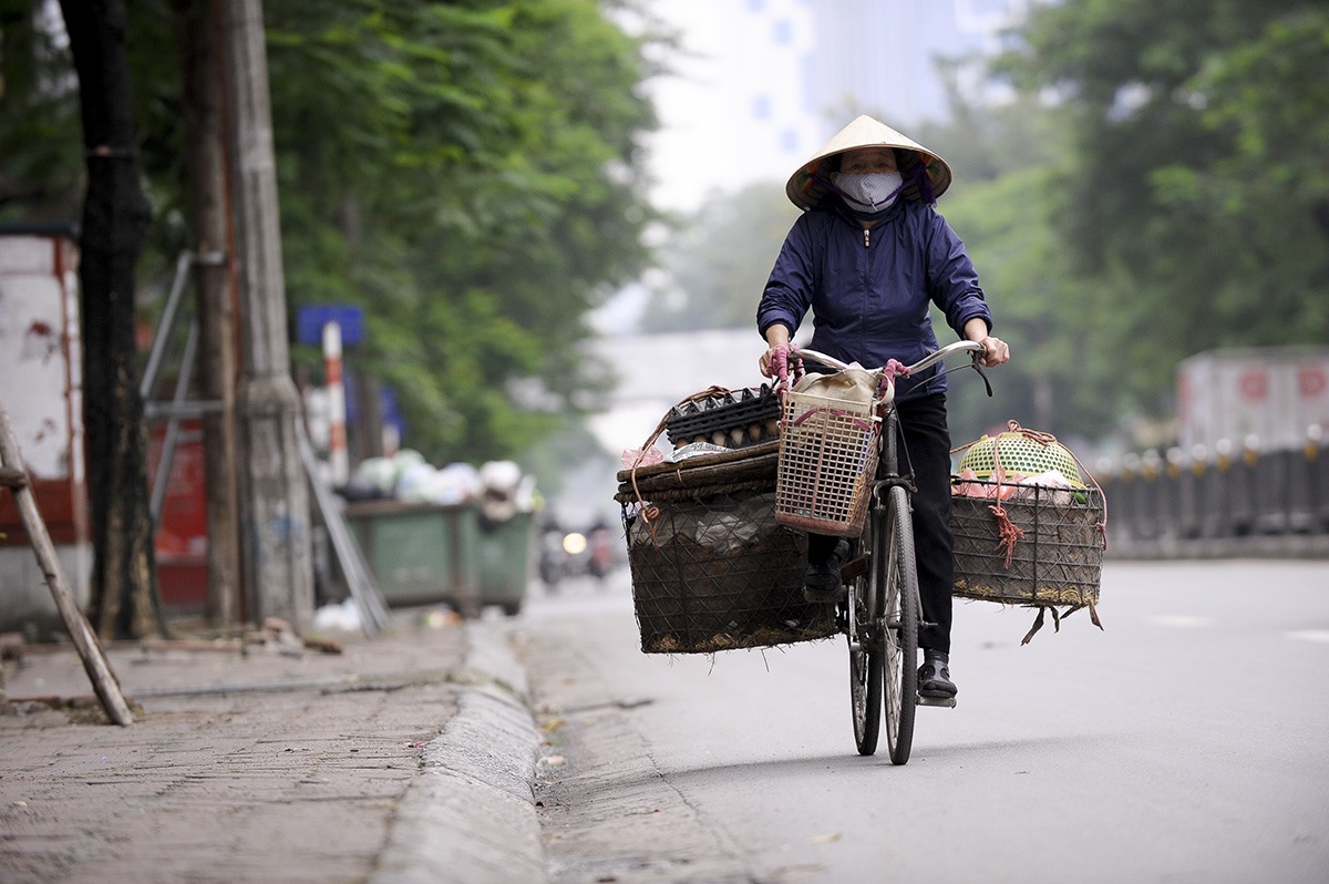 Thấp thoáng hình ảnh người lao động trên phố.