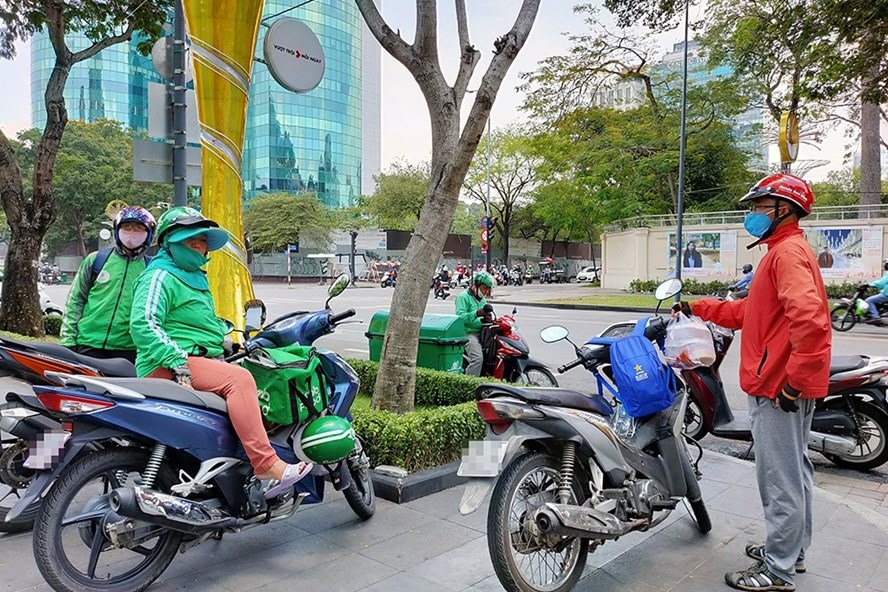 Các tài xế xe ôm công nghệ chờ khách. Ảnh: Thế Lâm.
