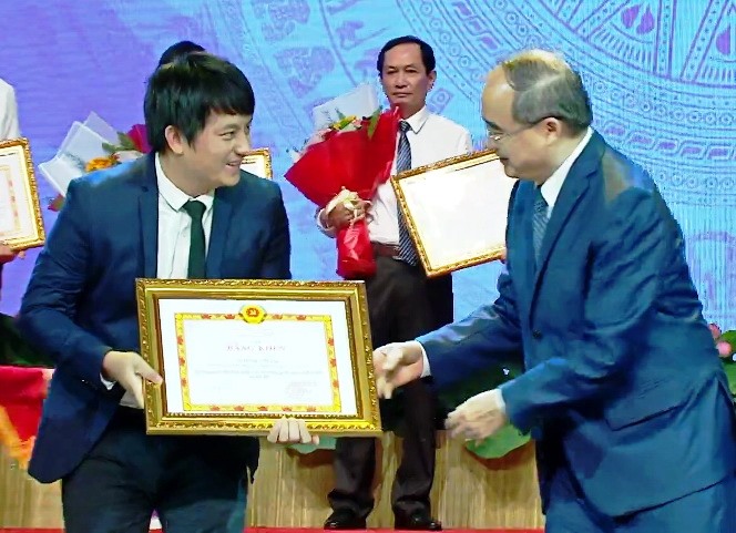 Bí thư Thành ủy Nguyễn Thiện Nhân tặng bằng khen cho chủ nhân sáng chế ra máy ATM gạo Hoàng Tuấn Anh. Ảnh: Tá Lâm