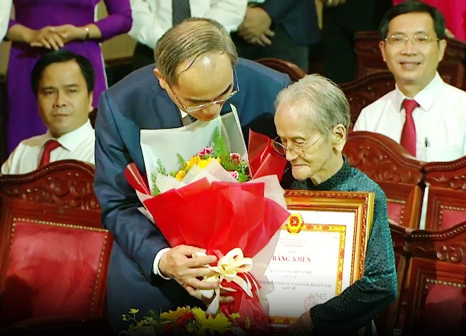 Bí thư Thành ủy Nguyễn Thiện Nhân trao bằng khen và tặng hoa cho mẹ Việt Nam anh hùng Ngô Thị Quýt. Ảnh: TÁ LÂM