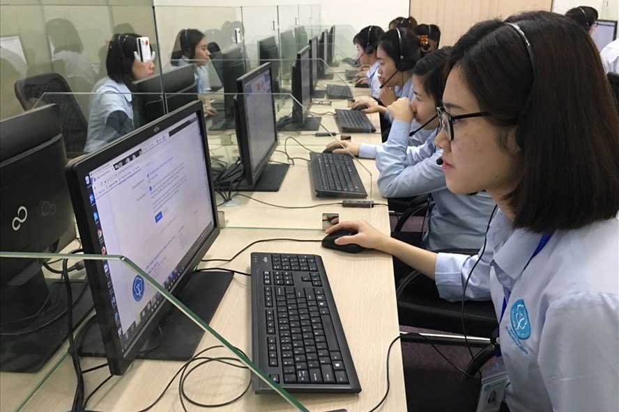 Nhân viên Trung tâm Dịch vụ khách hàng BHXH VN đang tư vấn cho người tham gia BHXH về chế độ, chính sách liên quan đến BHXH qua internet. Ảnh: H.A