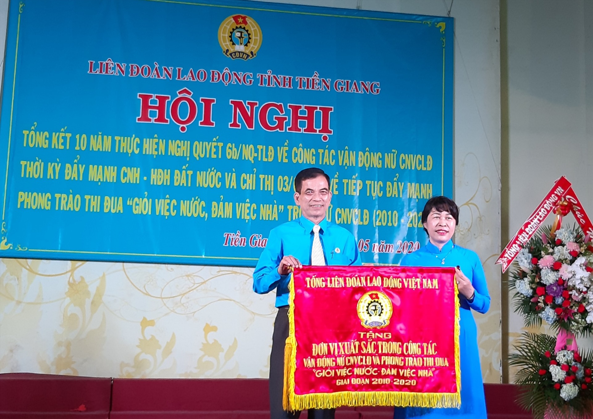 Bà Trịnh Thị Thanh Hằng trao cờ của Đoàn Chủ tịch Tổng LĐLĐ tặng tập thể LĐLĐ tỉnh Tiền Giang. Ảnh: K.Q