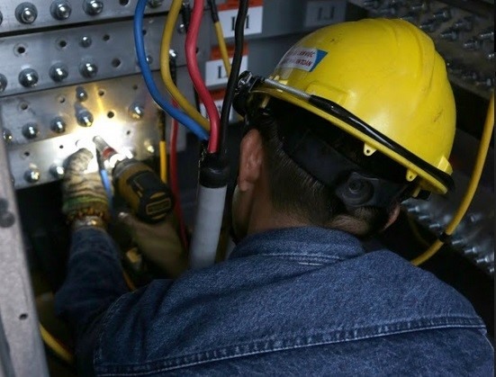 Công nhân EVNHCMC lắp đặt thiết bị lưu điện dự phòng cung cấp điện phục vụ các phiên họp trực tuyến tại điểm cầu TPHCM, kỳ họp thứ 9 Quốc hội khóa 14. Ảnh Công đoàn EVNHCMC cung cấp.