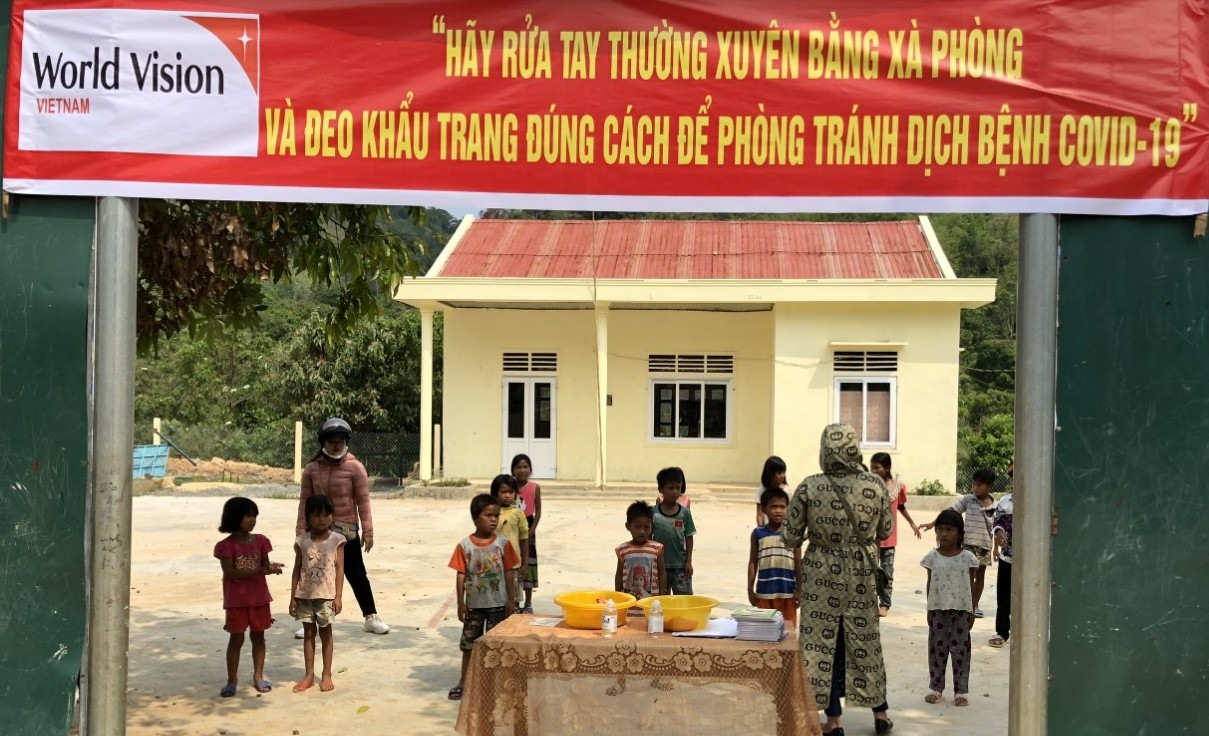 Giáo viên tặng khẩu trang cho học sinh, tuyên truyền cách phòng dịch COVID-19 và căn dặn học sinh đến trường vào ngày 3.5. Ảnh: MT.