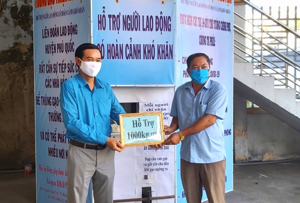 Ông Phan Xuân Trí (trái) tiếp nhận đóng góp của nhà hảo tâm. Ảnh: LT