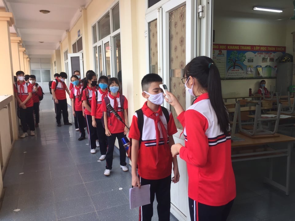 Chú thích: Học sinh Trường THCS Cao Thắng, Hạ Long, Quảng Ninh xếp hàng trước của lớp để đo thân nhiệt. Mọi thông số sẽ được ghi chép vào sổ theo dõi sức khỏe. Ảnh: Nguyễn Hùng