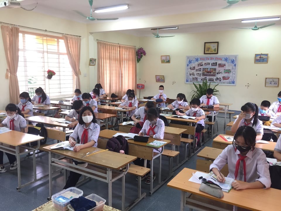 Chú thích: Học sinh Trường THCS Cao Thắng, Hạ Long, Quảng Ninh xếp hàng trước của lớp để đo thân nhiệt. Mọi thông số sẽ được ghi chép vào sổ theo dõi sức khỏe. Ảnh: Nguyễn Hùng