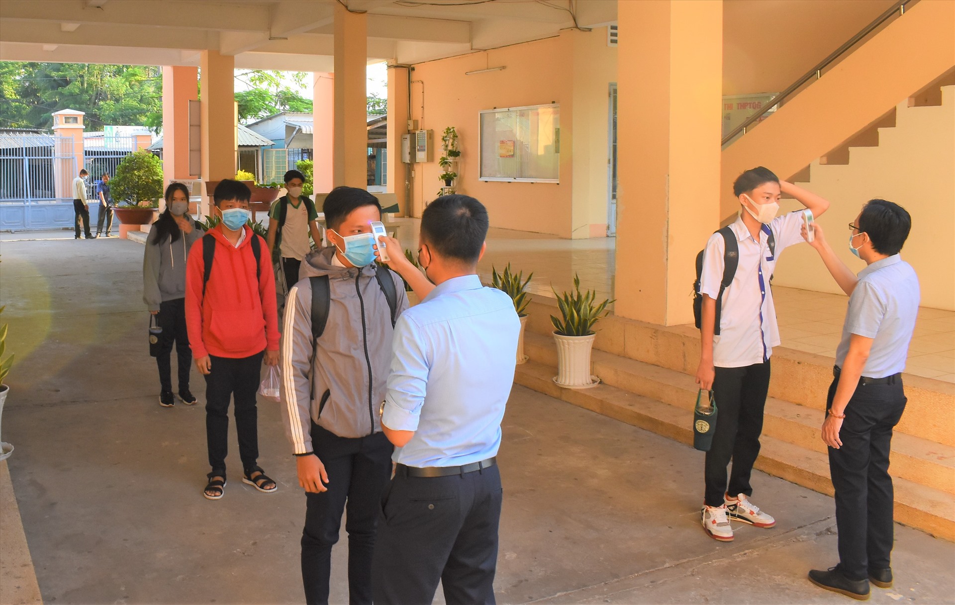 Kiểm tra thân nhiệt đối với các em học sinh khi trở lại học. Ảnh: Thành Nhân