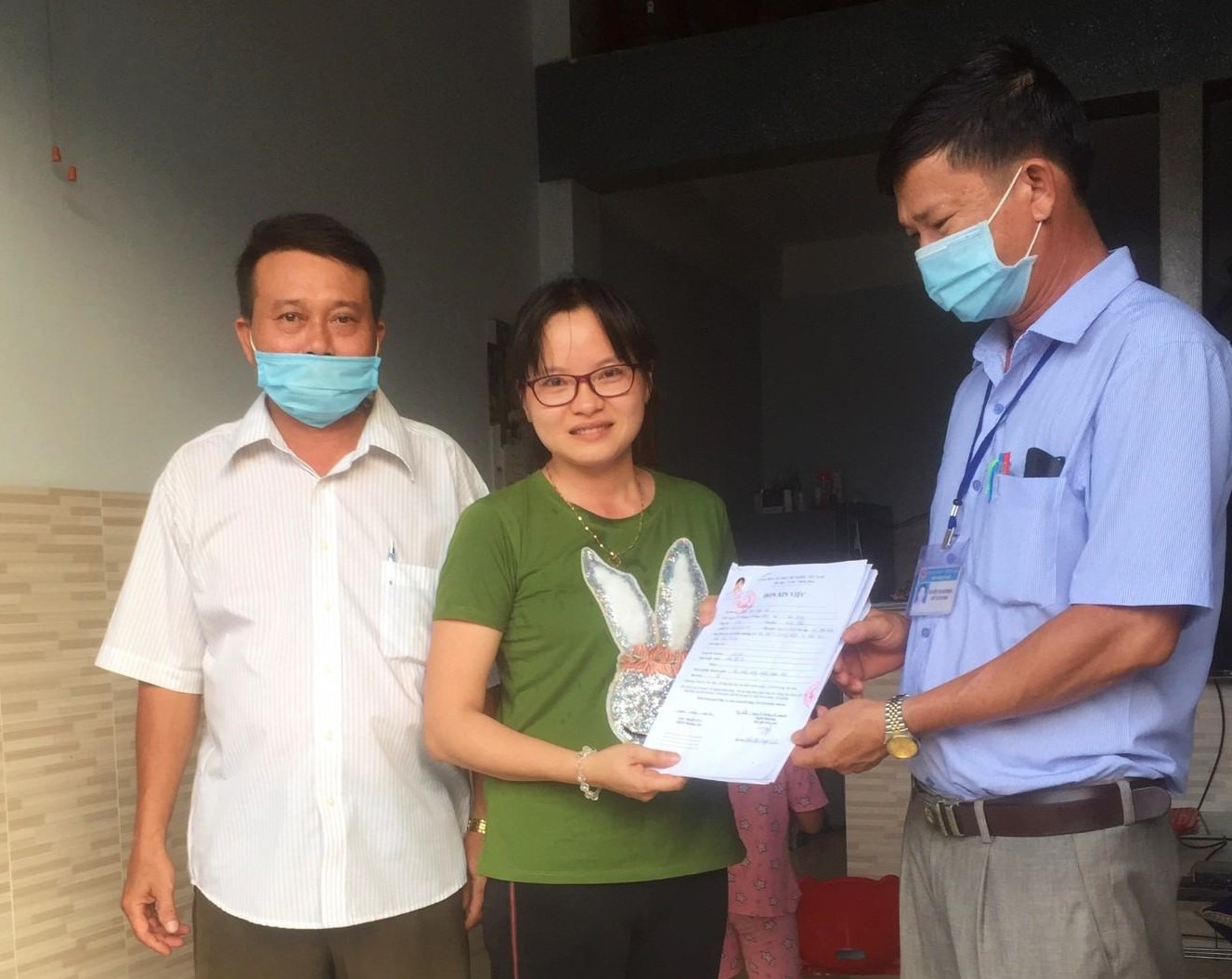 Ông Nguyễn Thanh Phong trả kết quả giải quyết chứng thực chữ ký, sao y CMND, hộ khẩu, bằng cấp tại nhà cho chị Trần Thị Ngọc Liên. Ảnh: Thao Nguyễn