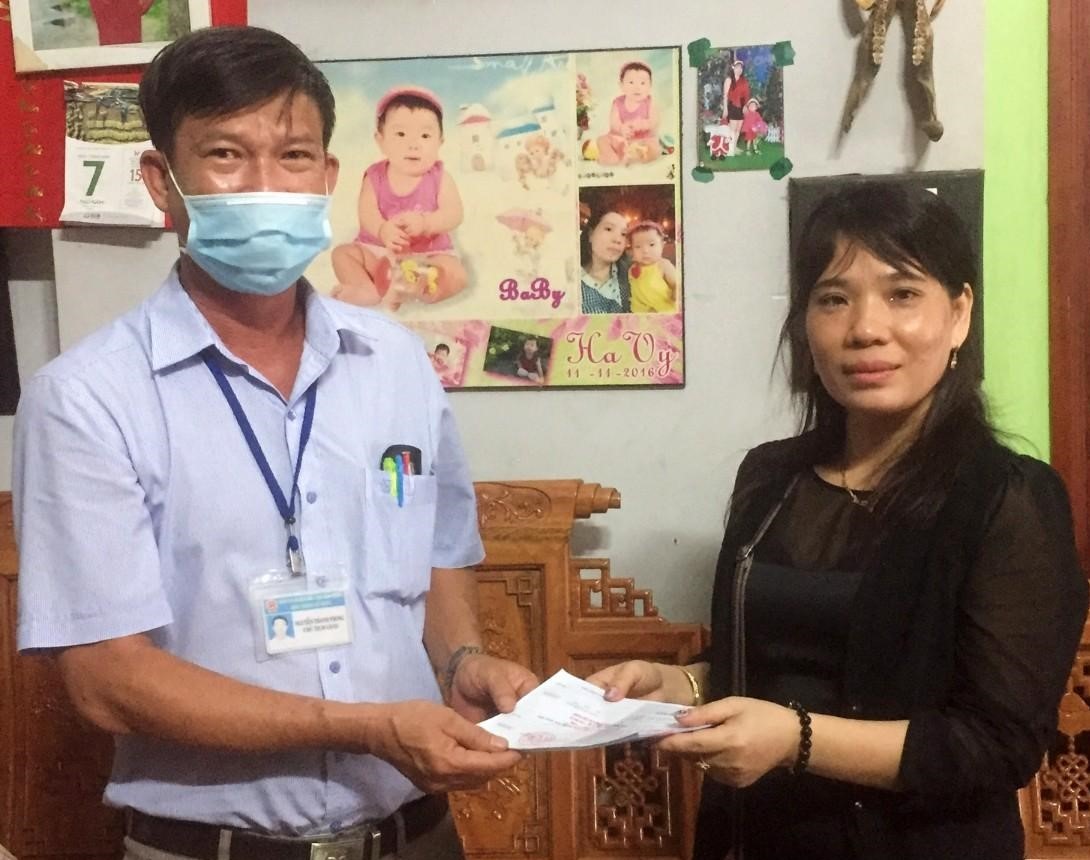 Ông Nguyễn Thanh Phong - Chủ tịch UBND phường Mỹ Phước trả kết quả giải quyết sao y hộ khẩu tại nhà cho chị Ngô Thị Hiếu chiều 7.5. Ảnh: Thao Nguyễn