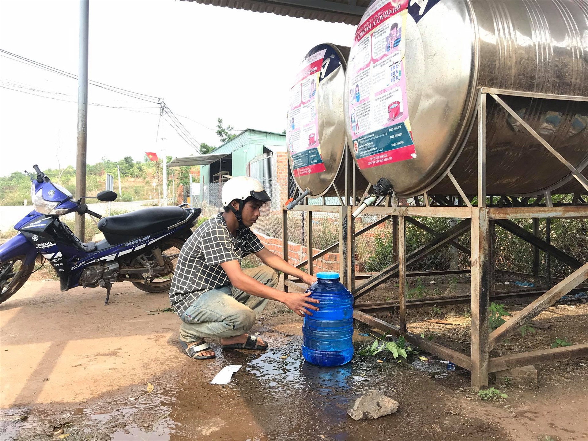 Nhiều tháng nay, người dân xã Ea Sin đang sử dụng ''tằn tiện'' nước ở bồn chứa công cộng. Ảnh: Bảo Trung