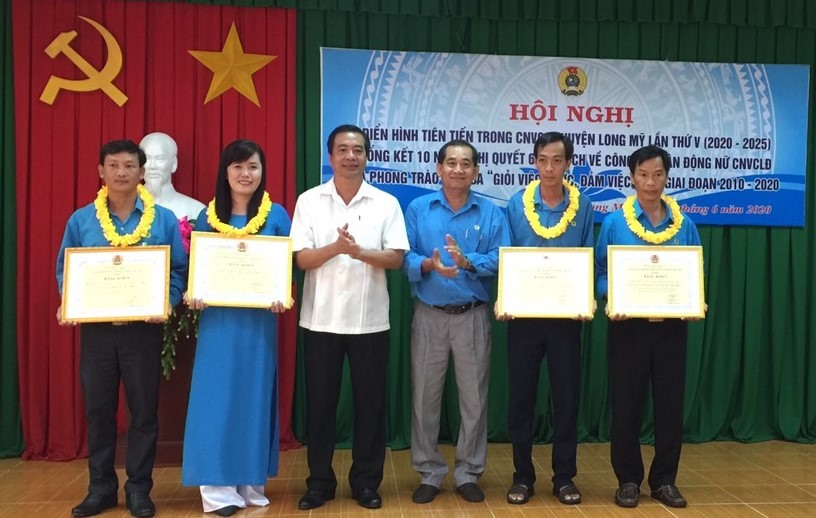 Đồng chí Kiều Văn Thọ, Phó Chủ tịch LĐLĐ tỉnh Hậu Giang và đồng chí Trần Thanh Liêm, Phó Bí thư Thường trực Huyện ủy Long Mỹ tặng Bằng khen của Tổng Liên đoàn Lao động Việt Nam cho các tập thể và cá nhân. Ảnh: Hoài Phúc