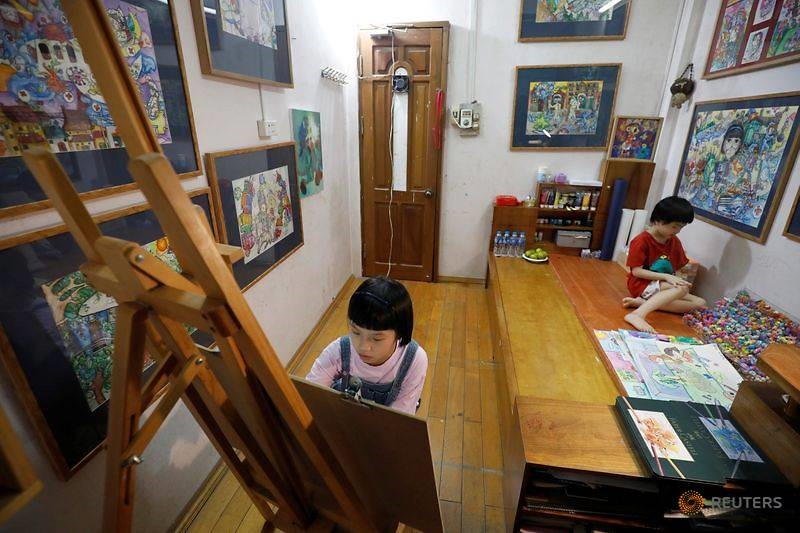 Nguyễn Đới Chung Anh đang vẽ tranh tại nhà. Ảnh: Reuters