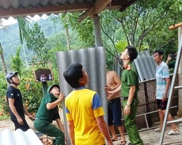 Công an, bộ đội và các đoàn thể tham gia giúp dân lợp lại nhà bị lốc xoáy tốc mái. Ảnh: TT.