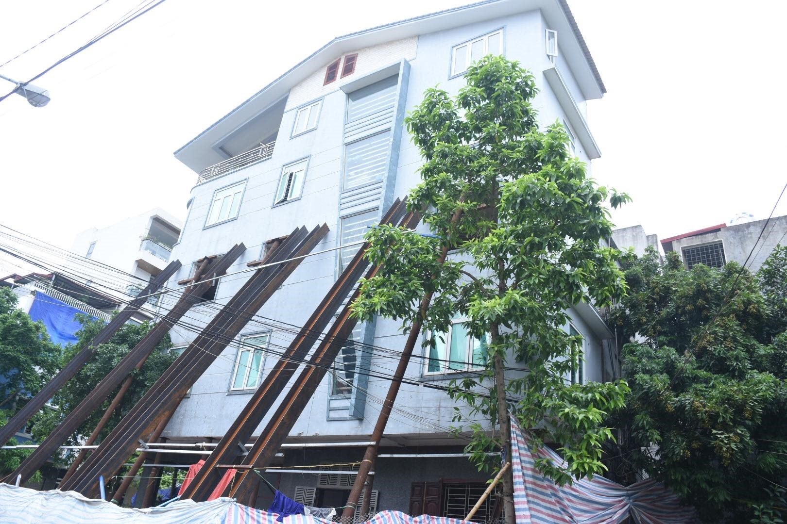 Hàng trăm cột sắt chống đỡ ngôi nhà nghiêng. Ảnh ĐL