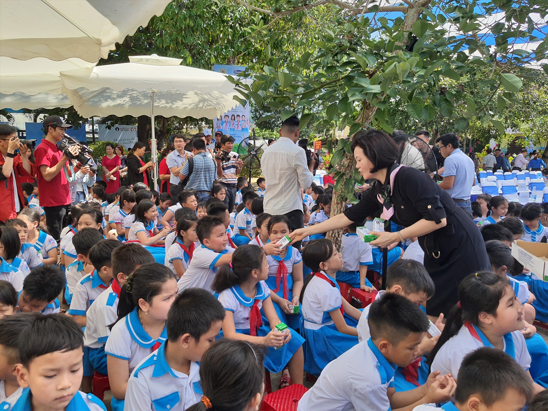 Các em học sinh trường Kim Đồng hồ hởi đón nhận những hộp sữa đầu tiên trong chương trình sữa học đường từ bà Bùi Thị Hương – Giám đốc Điều hành Vinamilk.
