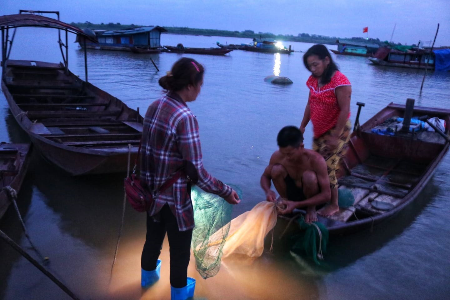 Tiểu thương đến thu mua cá của các hộ dân sinh sống trên sông khi trời còn chưa sáng tỏ.