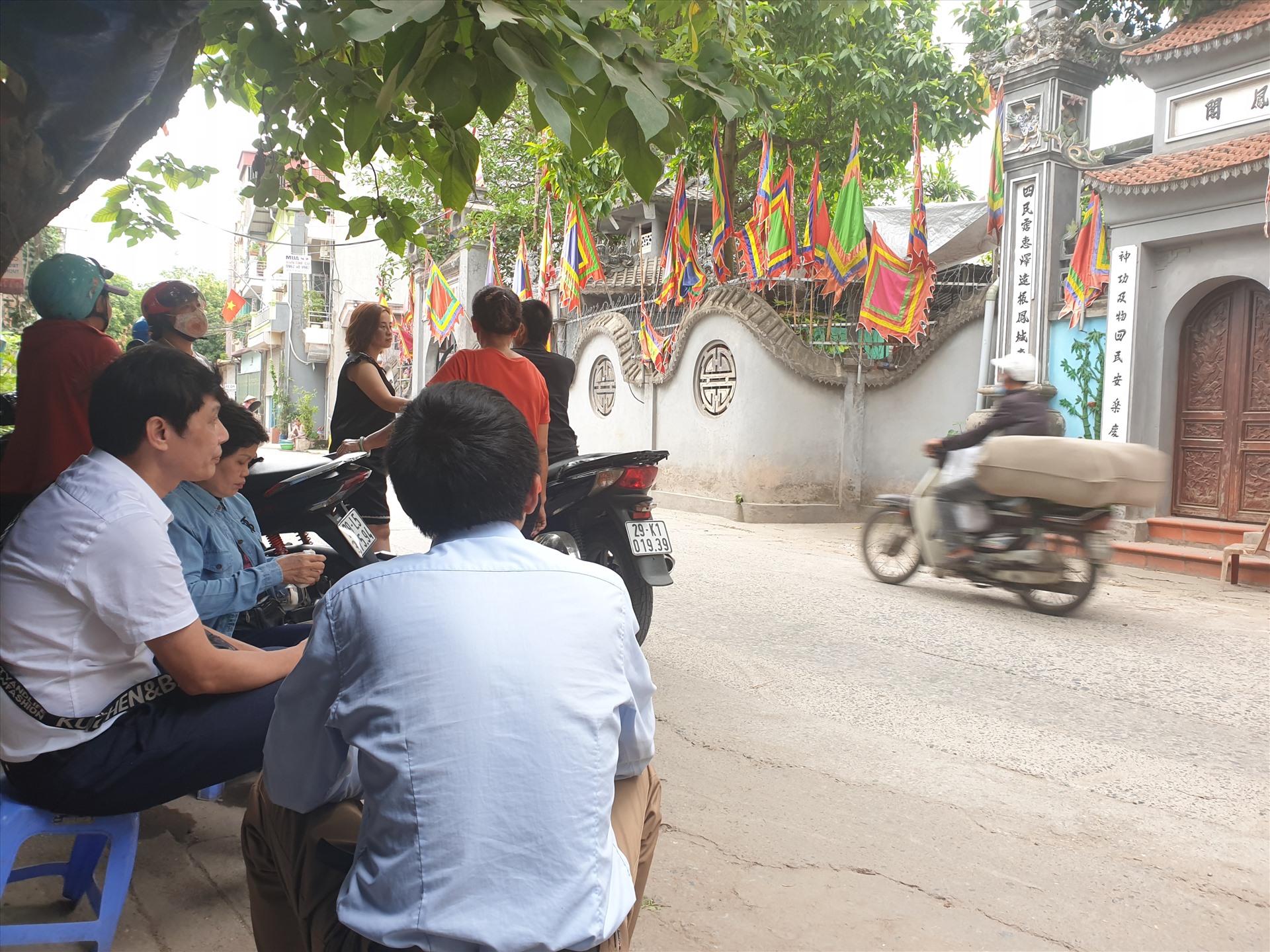 Người dân chờ bên ngoài cổng đền theo dõi vụ việc.