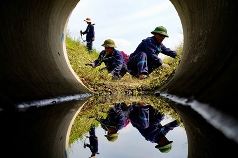 Đội bảo trì sân đường tiến hành cắt cỏ, nạo vét mương. Ảnh NIA