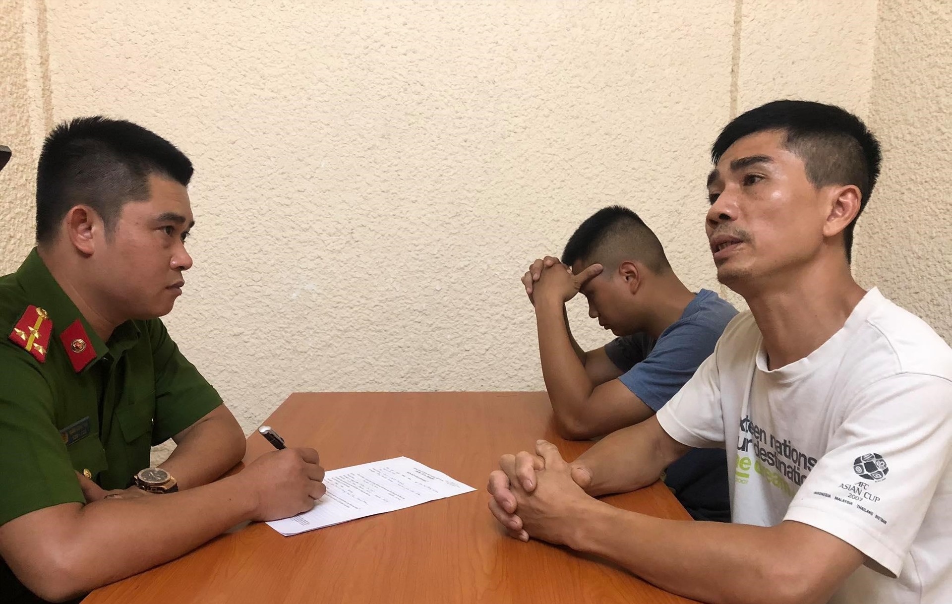 Công an lấy lời khai của một chủ cửa hàng mua gương ô tô của nhóm trộm (áo trắng) và đạo chích (ngồi trong cùng). Ảnh: Việt Dũng.