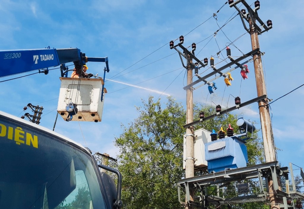 Các công nhân Điện lực huyện Hoằng Hóa phun nước rửa sứ, kiểm tra lưới điện. Ảnh: Q.D