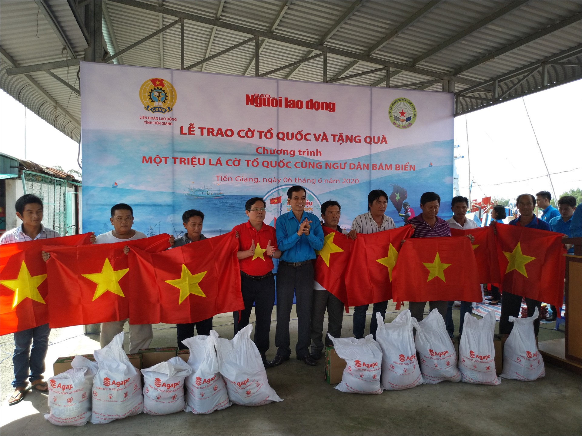 Lãnh đạo Liên đoàn Lao động tỉnh Tiền Giang và Báo Người Lao Động trao cờ và quà cho ngư dân. Ảnh: K.Q