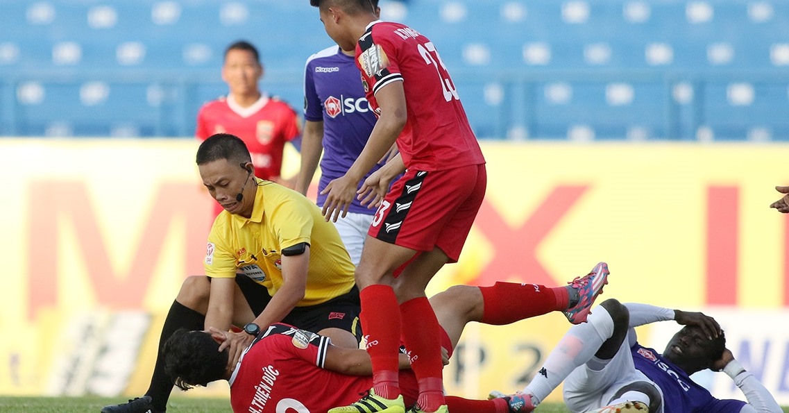 Hành động đẹp của ông Ngô Duy Lân khi sơ cứu cho Nguyễn Hùng Thiện Đức tại V.League 2019. Ảnh: Hữu Phạm.