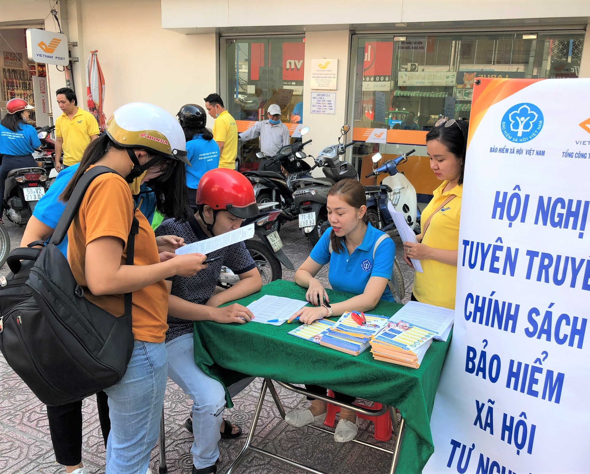 Nhân viên ngành BHXH tư vấn cho người dân về BHXH tự nguyện và BHYT hộ gia đình. Ảnh Đức Long