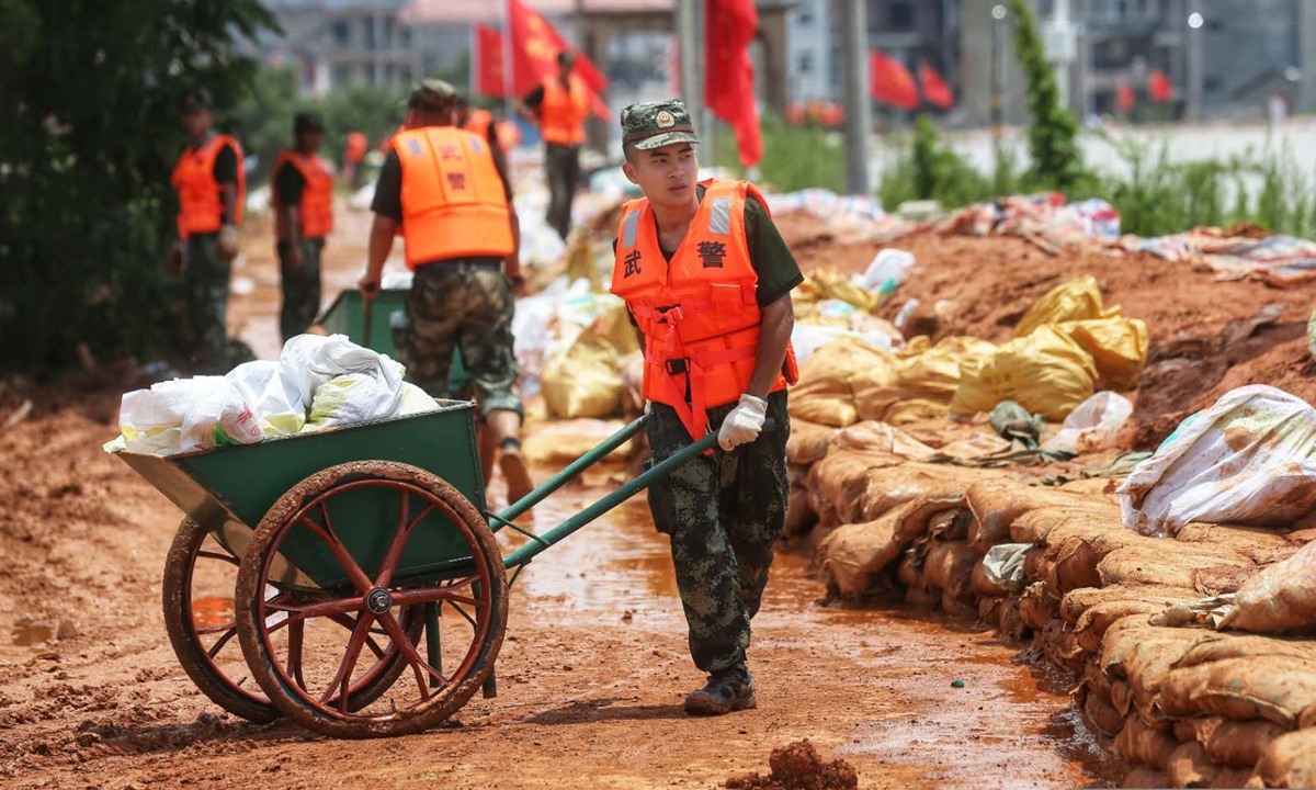 Một người lính đang chuyển bao cát phục vụ công tác gia cố đê. Ảnh: GT