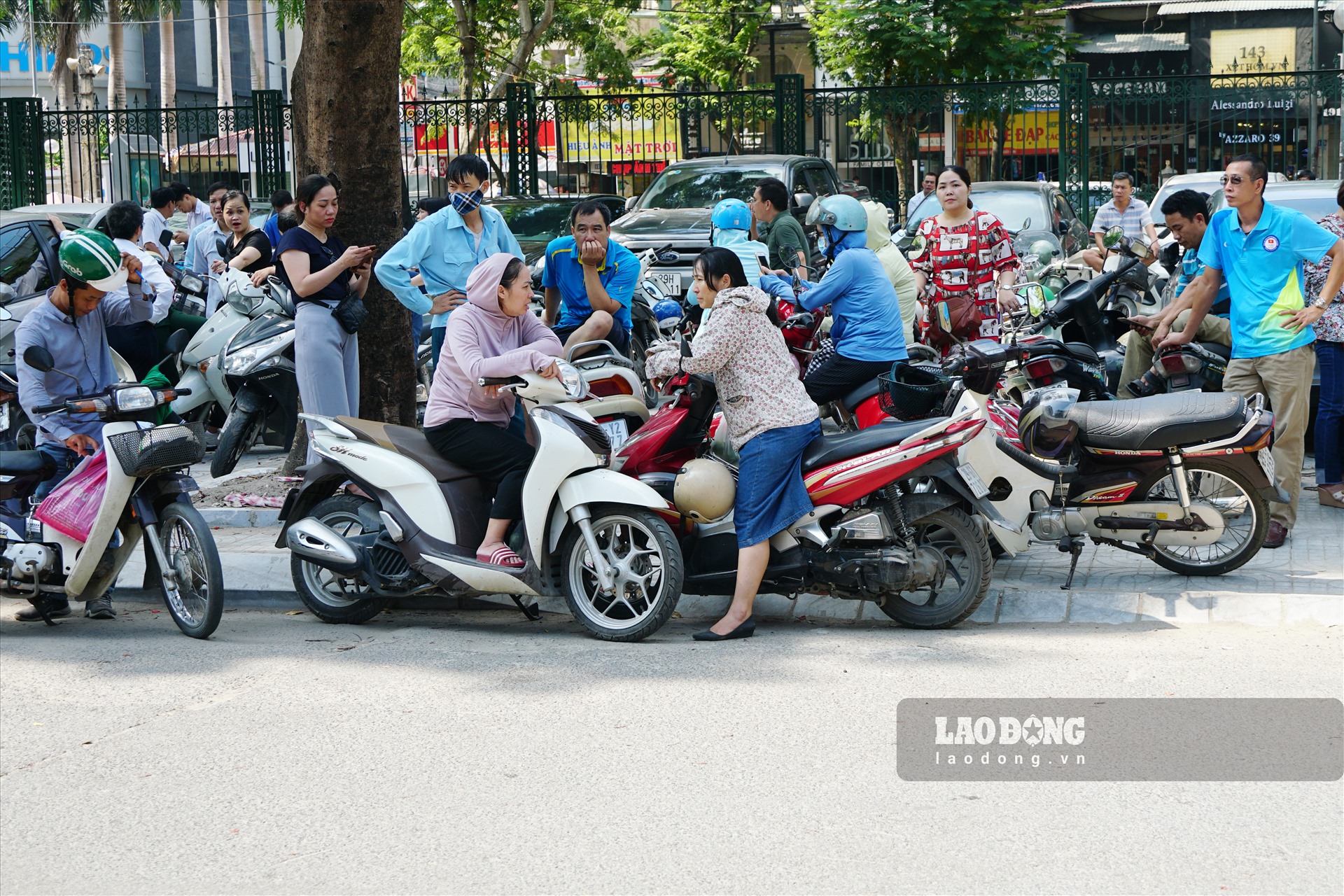 Thời tiết oi nắng khiến các bậc phụ huynh mệt mỏi khi phải đứng đợi.