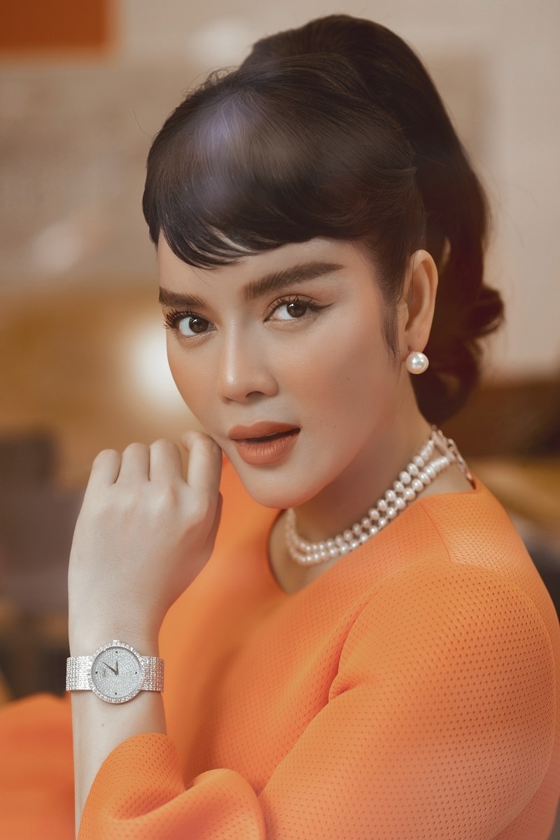 Cô phối phụ kiện ngọc trai và đồng hồ đính kim cương.