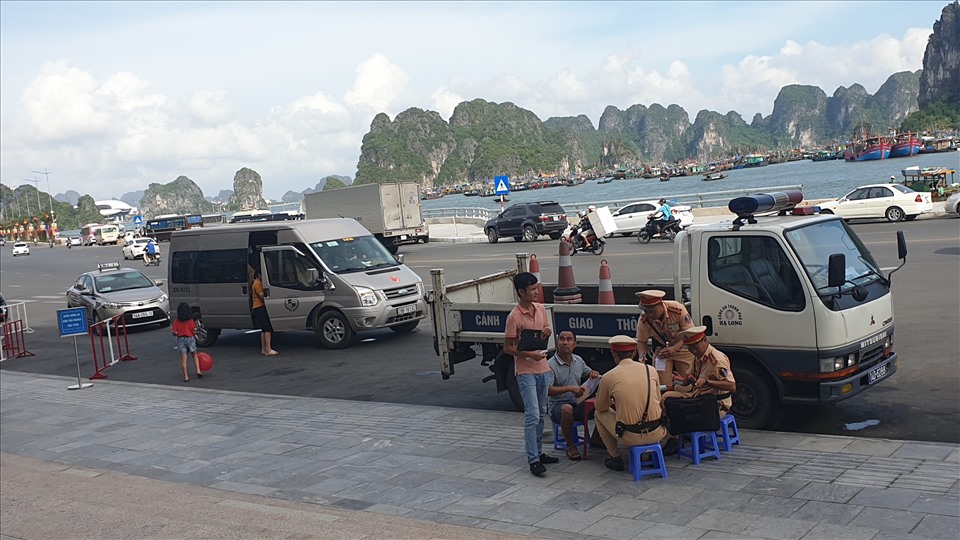 Du khách, người dân đợi làm thủ tục nộp phạt do đỗ xe không đúng quy định. Ảnh: Nguyễn Hùng