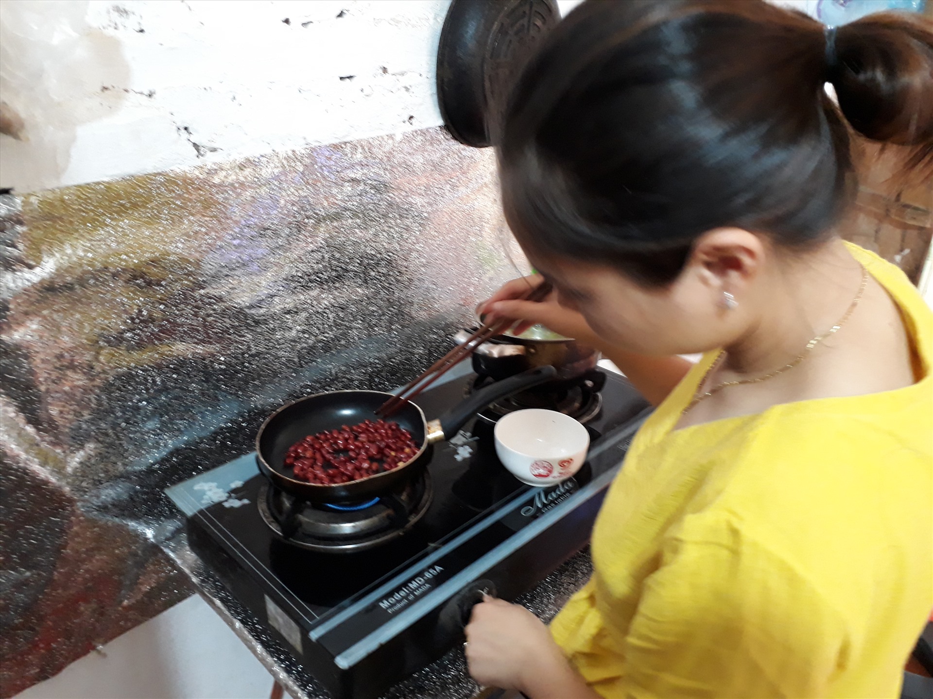 Chị Hoàng Thị Nông đang nấu bữa cơm trưa cho một mình mình. Ảnh: Bảo Hân.
