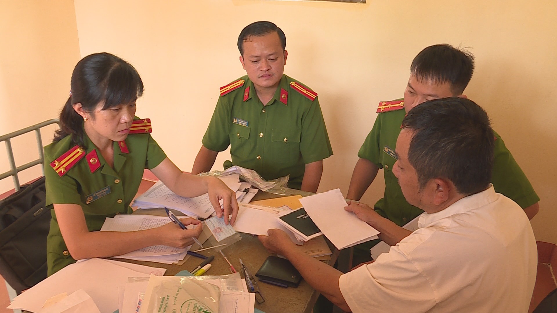 Ông Tuệ (áo trắng) làm việc tại cơ quan công an. Ảnh: Lin xong