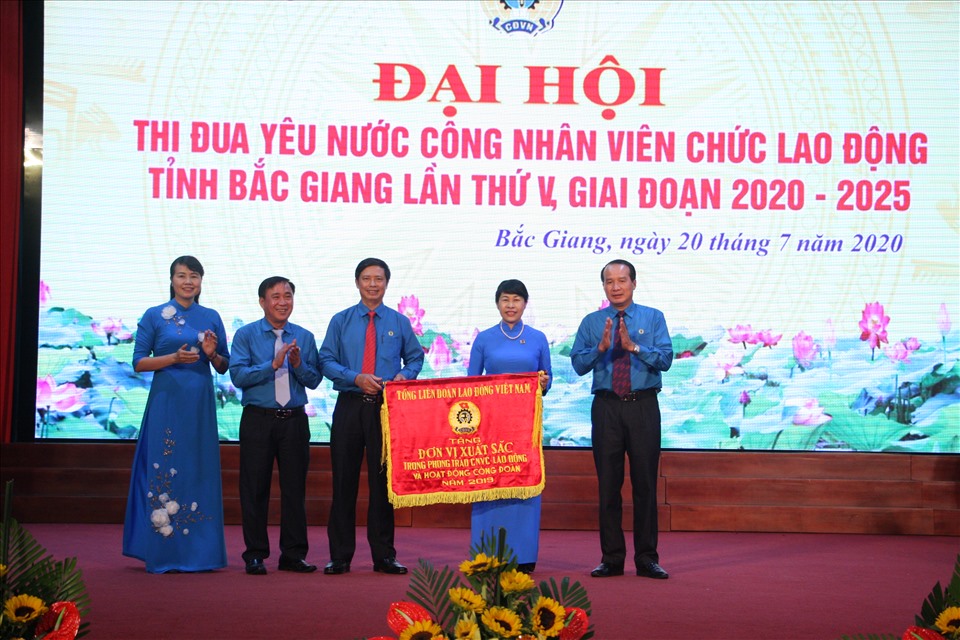 Đồng chí Trịnh Thanh Hằng - Ủy viên Đoàn Chủ tịch, Trưởng ban Nữ công Tổng LĐLĐVN - trao Cờ thi đua tới Liên đoàn Lao động tỉnh Bắc Giang vì đã có thành tích xuất trong phong trào CNVCLĐ và hoạt động CĐ năm 2019. Ảnh: Đỗ Quyên.