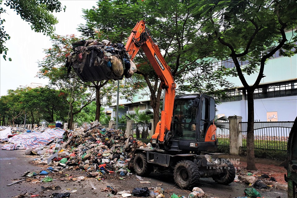 Máy xúc phục vụ gom rác hoạt động hết công suất.