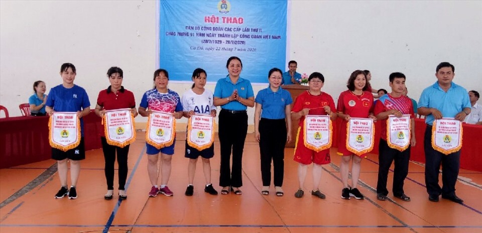 Lãnh đạo LĐLĐ TP.Cần Thơ và lãnh đạo LĐLĐ huyện Cờ Đỏ trao cờ lưu niệm cho các đội tham dự hội thao. Ảnh: Văn Thừa