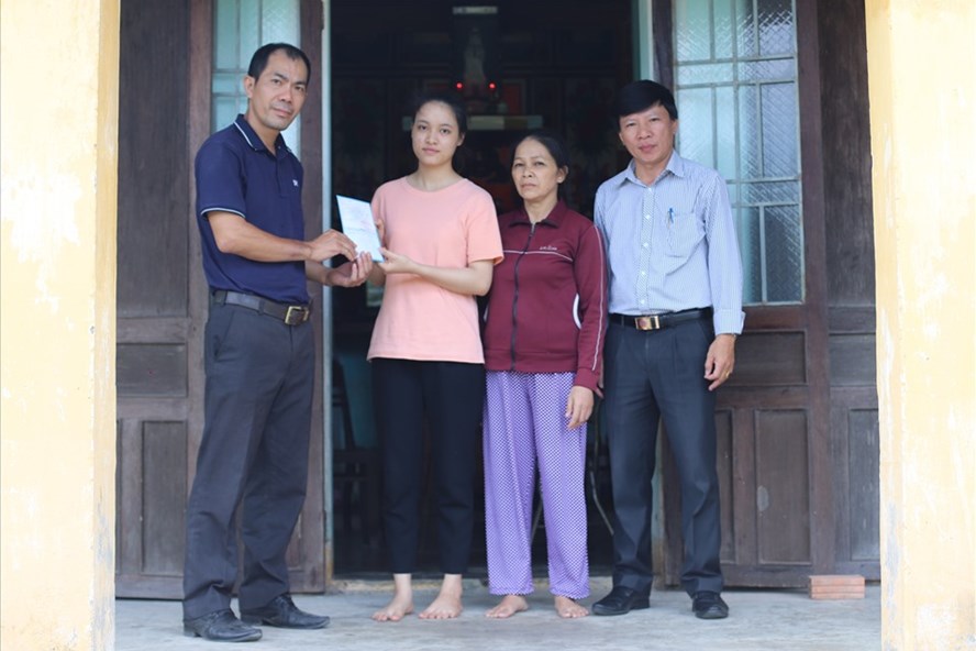 Đại diện Báo Lao Động tại miền Trung - Tây Nguyên trao 1 cuốn sổ tiết kiểm trị giá 10 triệu đồng cho em Nguyễn Thanh Thúy.