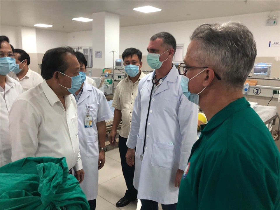 Phó Thủ tướng Thường trực Trương Hoà Bình (bên trái) trao đổi với các chuyên gia Cu Ba về tình hình cứu chữa các nạn nhân. Ảnh: Lê Phi Long