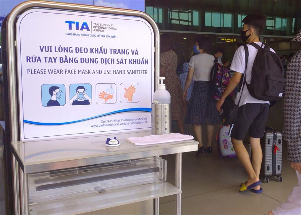 Bảng thông báo nhắc nhở đeo khẩu trang và rửa tay bằng dung dịch sát khuẩn tại Cảng hàng không Tân Sơn Nhất. Ảnh: CHÂN PHÚC