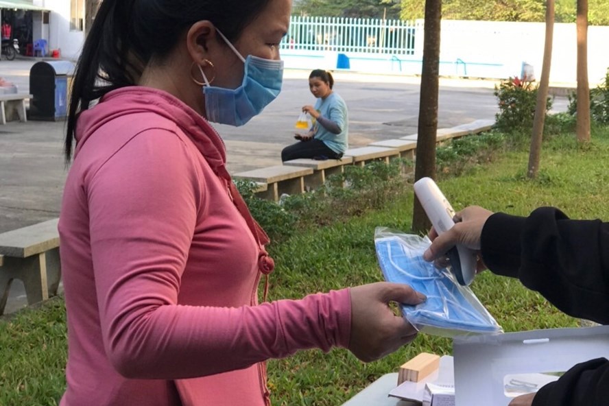 Công ty Vinakad phát khẩu trang và đo thân nhiệt cho công nhân.
Ảnh: Hồ Sỹ Tân